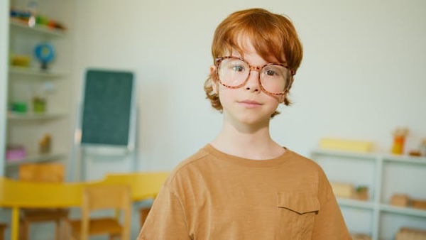 child with glasses in a classroom