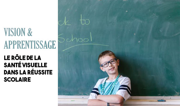 smiling child in front of a blackboard
