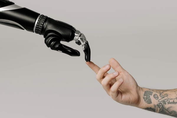 tattooed arm and robotic arm touch