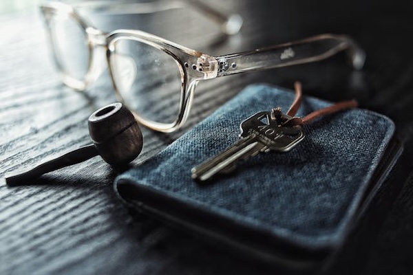 glasses placed on a table with a key and wallet