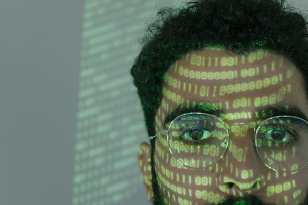 close-up of a face with glasses and projected digital writing